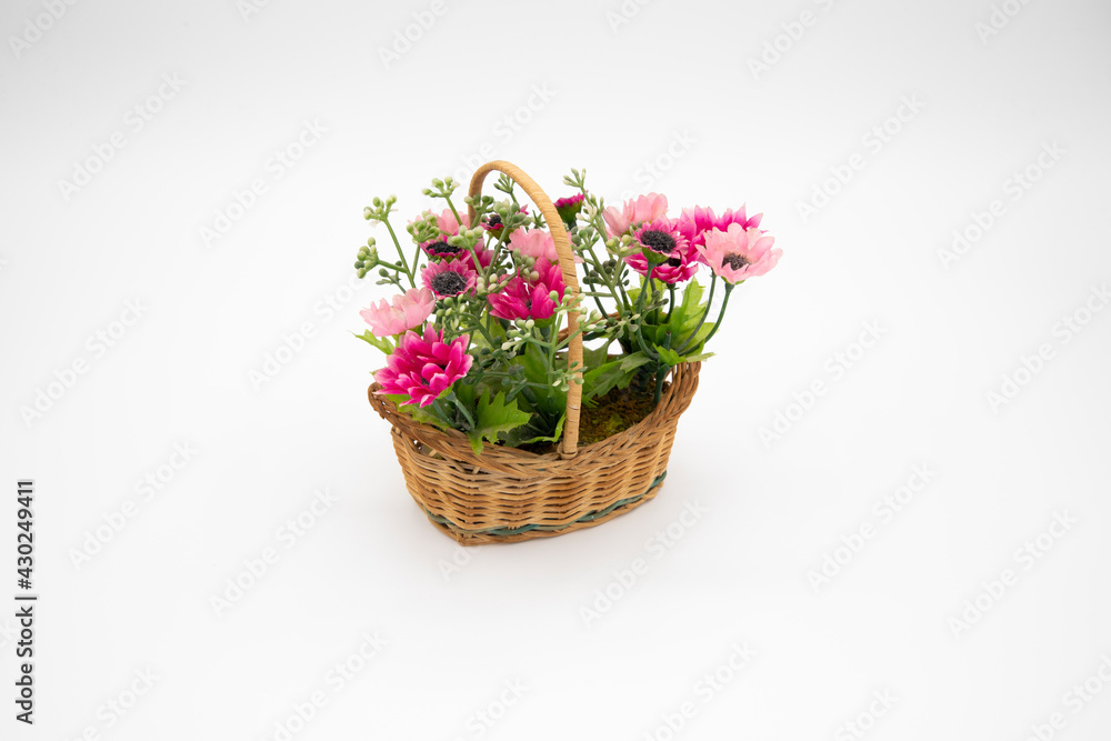 Handmade colorful synthetic flowers in closeup basket isolated on white background and copy space