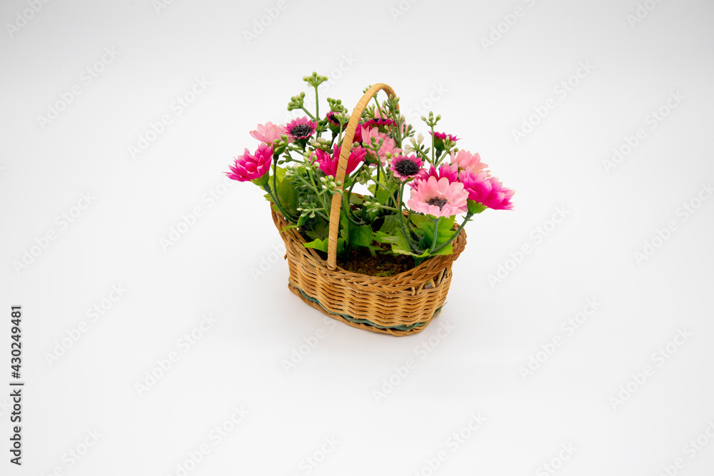 Handmade colorful synthetic flowers in closeup basket isolated on white background and copy space