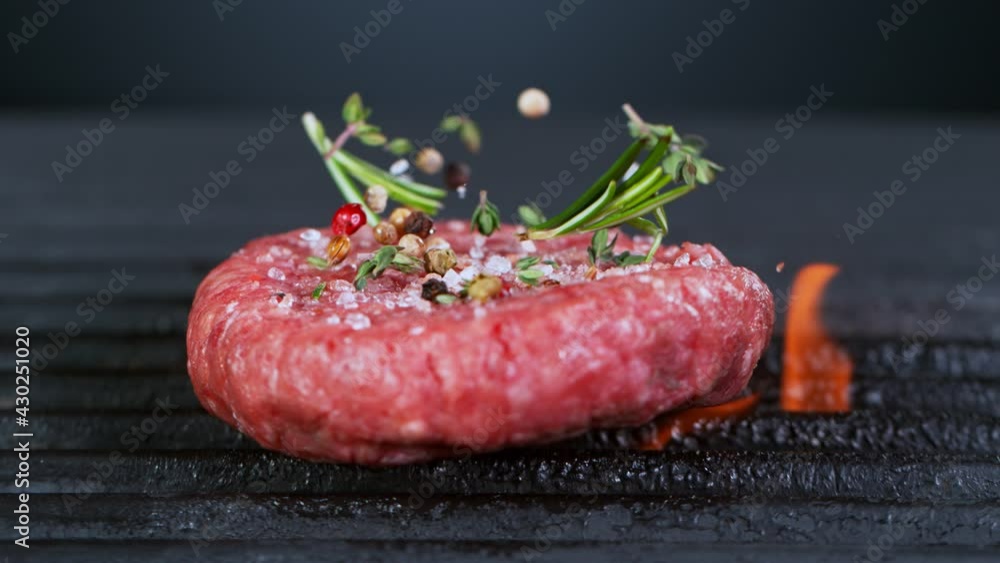 Super Slow Motion Shot of Falling Fresh Beef Hamburger Meat with Herbs on Grill at 1000 fps. Super Slow Motion Shot of Falling Fresh Beef Hamburger Meat with Herbs on Grill at 1000 fps.