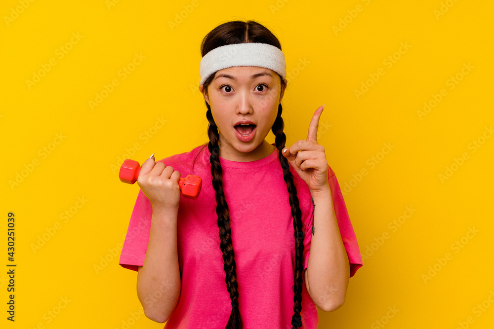 Young sport chinese woman isolated on yellow background having an idea, inspiration concept. Young sport chinese woman isolated on yellow background having an idea, inspiration concept.