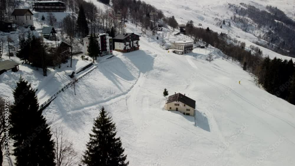 An aerial view of an empty ski resort with no people due to coronavirus restrictions on a sunny day in Italy. An aerial view of an empty ski resort with no people due to coronavirus restrictions on a sunny day in Italy.