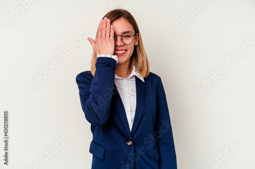 Young business caucasian woman isolated on white background having fun covering half of face with palm.