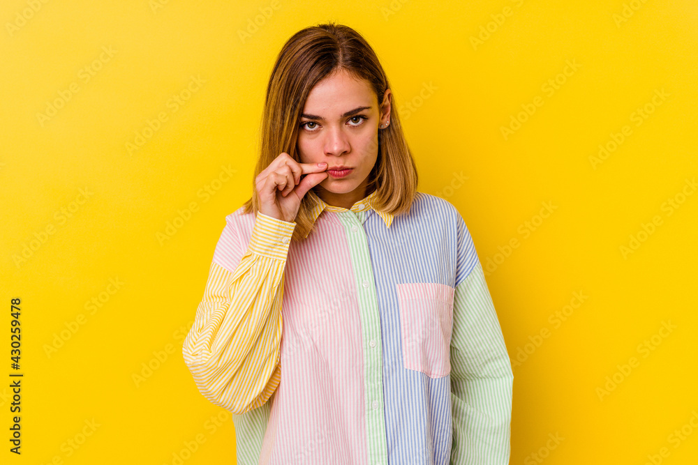 Young caucasian skinny woman isolated on yellow background with fingers on lips keeping a secret. Young caucasian skinny woman isolated on yellow background with fingers on lips keeping a secret.