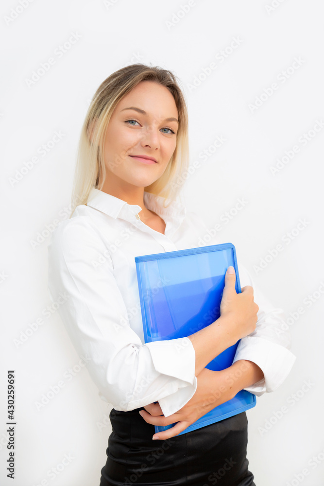 Beautiful young business woman smiling looking at camera with blue folder in hands, with white background. Beautiful young business woman smiling looking at camera with blue folder in hands, with white background.