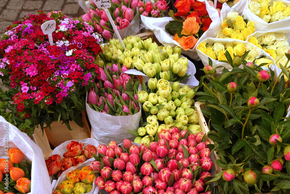 Stand mit bunten Sträußen aus Tulpen und Pfingstrosen auf einem Markt