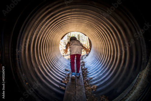 Little child going through a tunnel in a playground