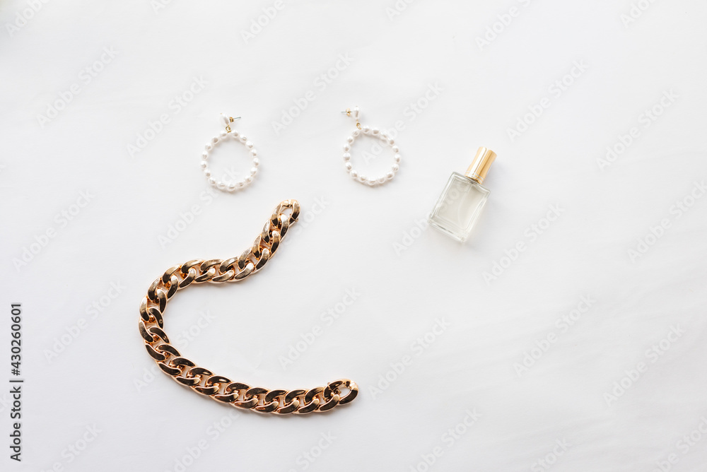White and gold jewelry collection: chain, pearl earrings, hairpin, perfume. Jewelry for a woman. High quality photo White and gold jewelry collection: chain, pearl earrings, hairpin, perfume. Jewelry for a woman. High quality photo