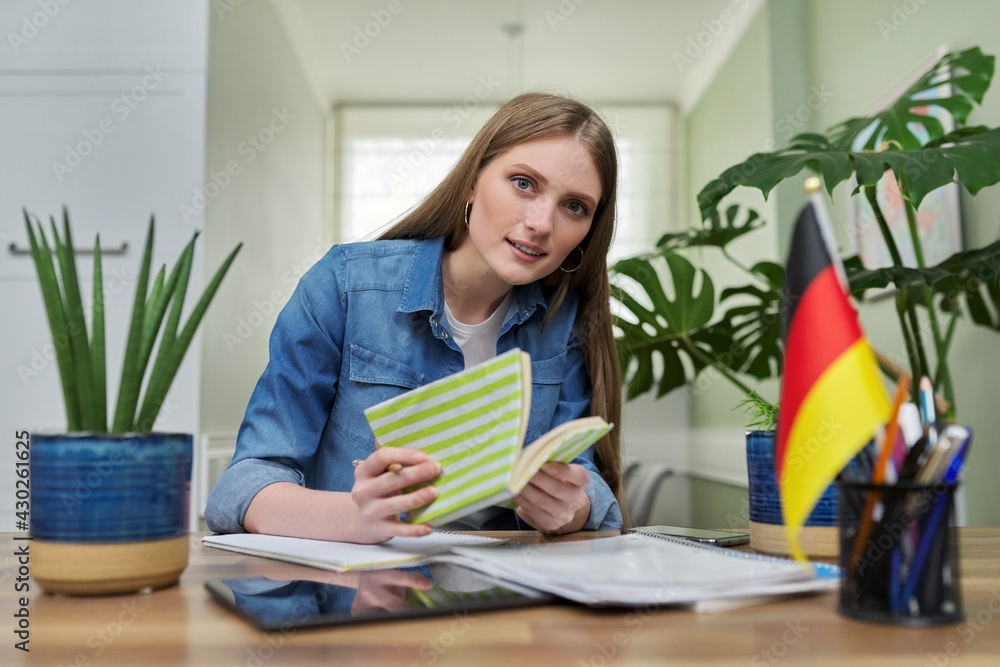Female student looking talking to webcam, studying German online Female student looking talking to webcam, studying German online