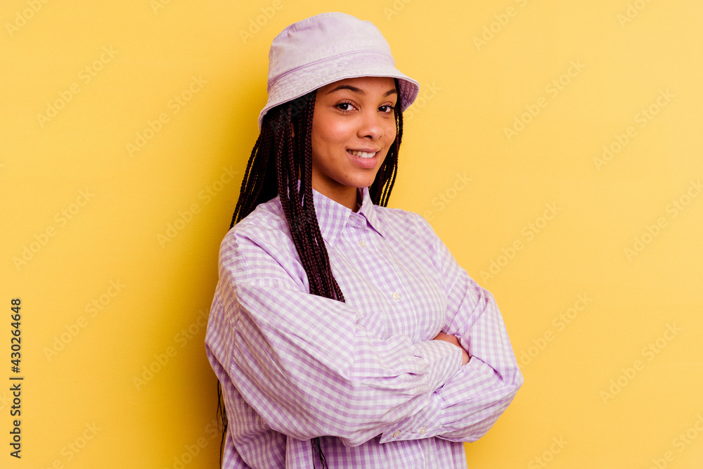 Young african american woman isolated on yellow background laughing and having fun. Young african american woman isolated on yellow background laughing and having fun.