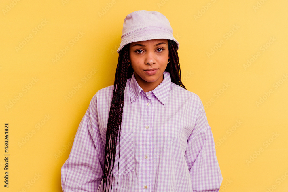 Young african american woman isolated on yellow background sad, serious face, feeling miserable and displeased.