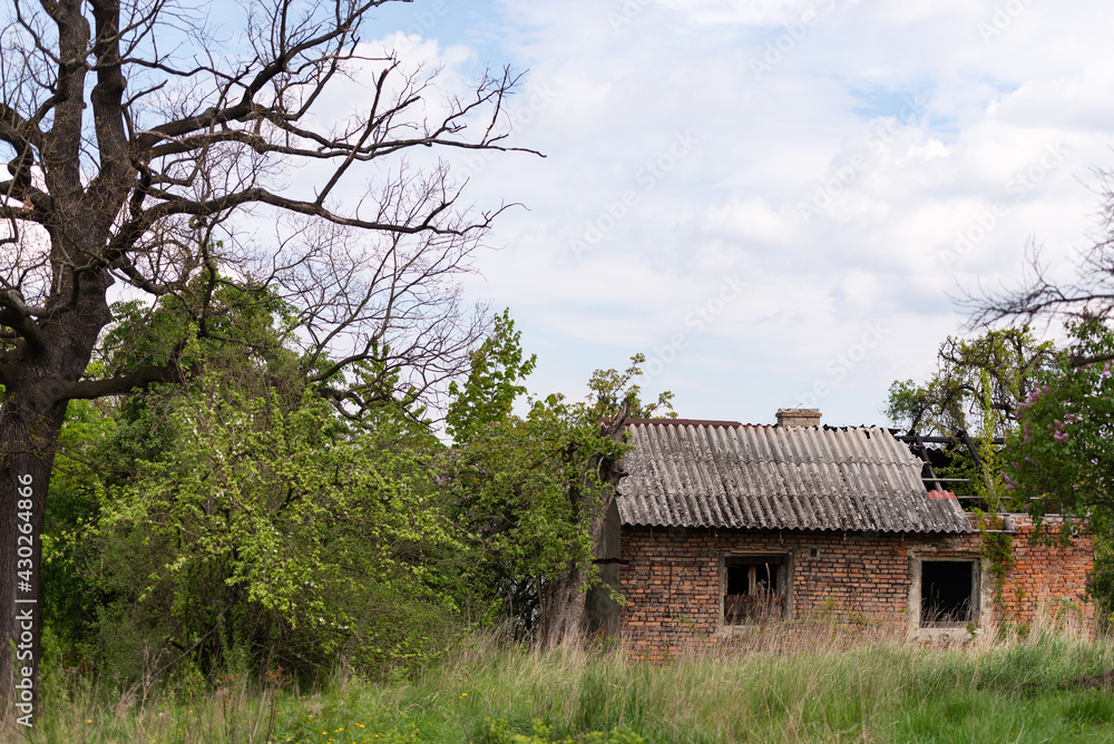 Old village house near Krakow. Abandoned brick house after fire. Old slate and charred beams. Old village house near Krakow. Abandoned brick house after fire. Old slate and charred beams.