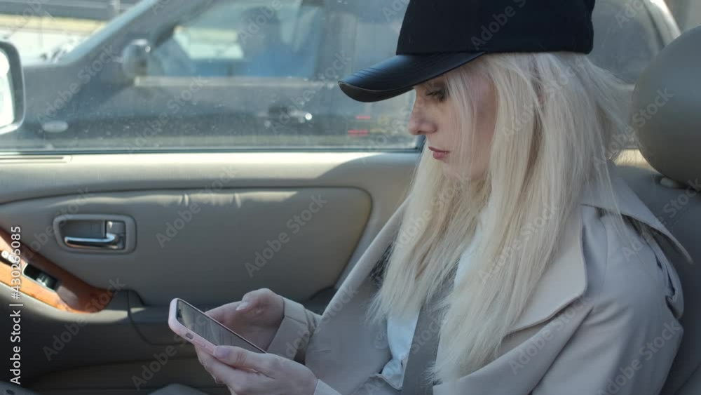 fashionable woman with smartphone sitting in car