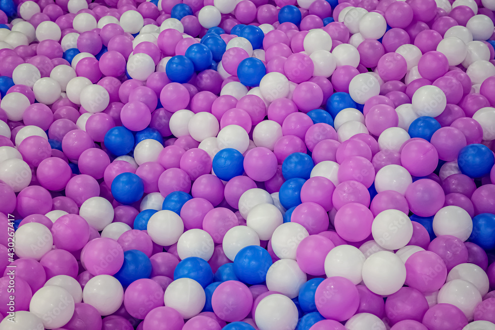 Heap of colorful plastic balls in white, blue and purple colors.