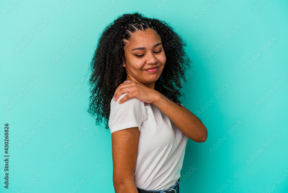 Young african american woman isolated on blue background having a shoulder pain. Young african american woman isolated on blue background having a shoulder pain.