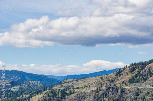 mountains in Okanagan valley and blue sky with clouds.