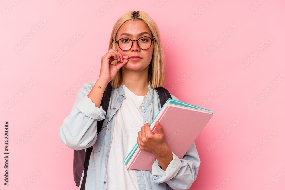 Young venezuelan student woman isolated on pink background with fingers on lips keeping a secret. Young venezuelan student woman isolated on pink background with fingers on lips keeping a secret.