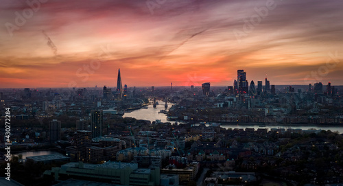 Wide panoramic aerial view to the skyline of London, England, during a colorful sunset with red and pink cloudscape © moofushi
