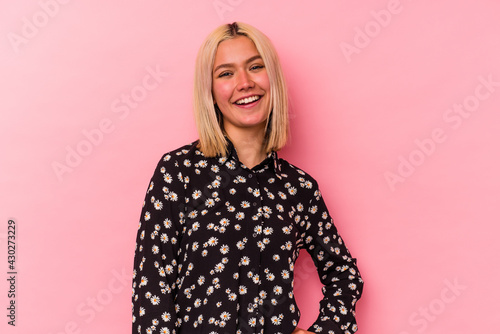 Young venezuelan woman isolated on pink background confident keeping hands on hips. © Asier