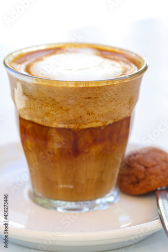 Decorated glass of Coffee Piccolo Latte milk froth design
