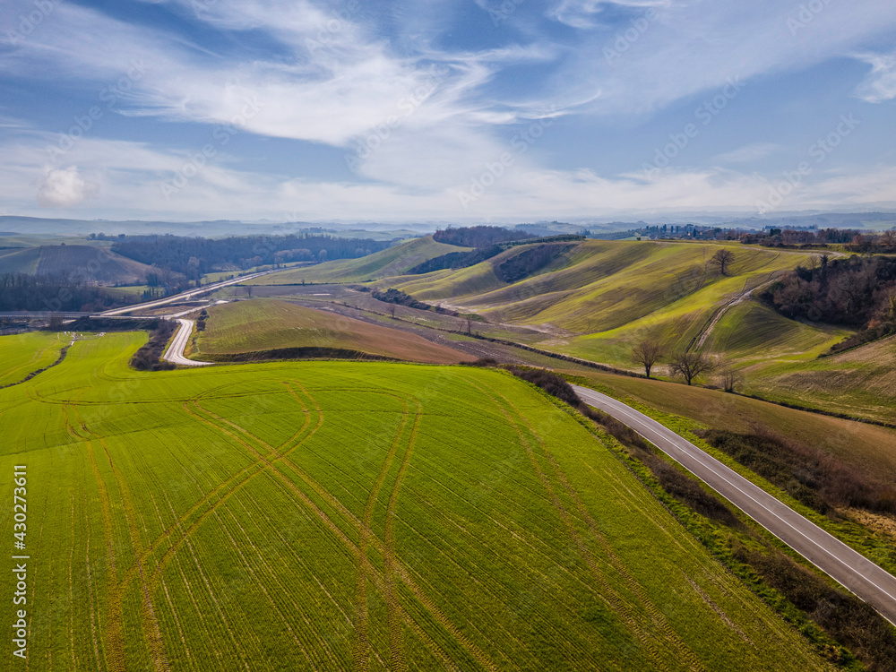 Naklejka premium Road in the middle of an idyllic countryside landscape. Drone view, aerial shot.