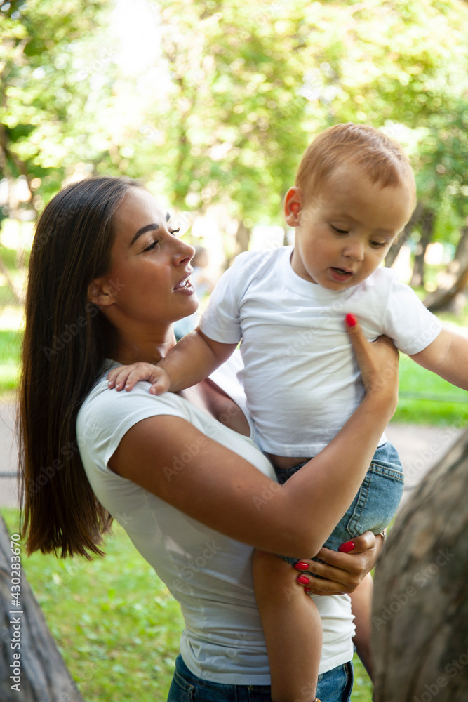 young pretty brunette mother with little cute boy walking in park happy smiling, lifestyle people concept young pretty brunette mother with little cute boy walking in park happy smiling, lifestyle people concept