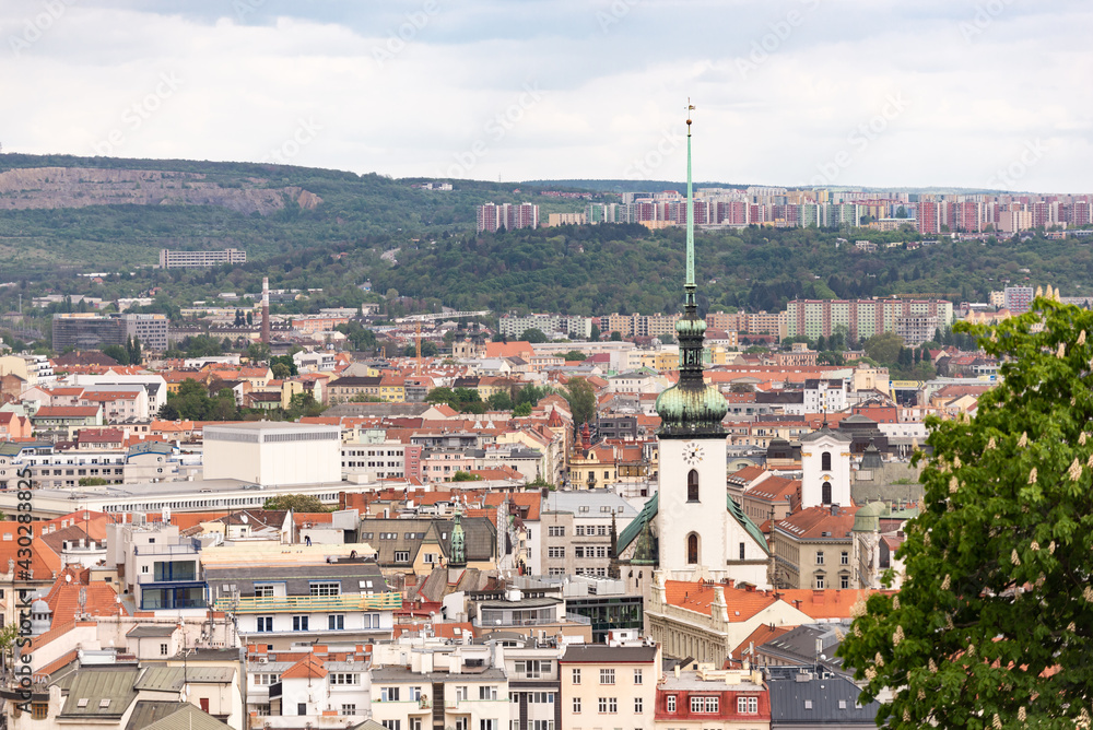 Brno. Czech. Spring 2019. Panorama of the center of Brno. Old quarter with church and panel construction on the hill.