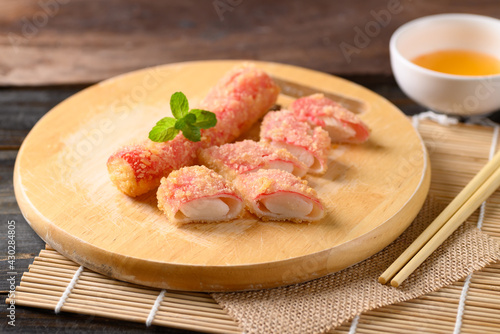 Deep fried crab sticks or surimi on wooden board eating with chili sauce