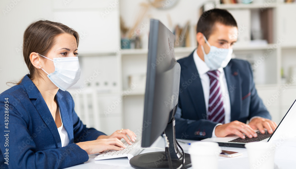 Fototapeta premium Manager in protective medical mask gives task to assistant at office
