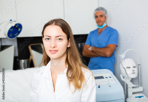 Portrait of young confident woman visiting modern clinic of aesthetic cosmetology.