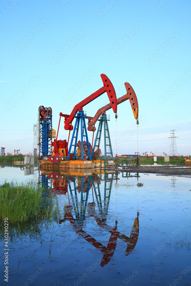 Oil pump under the blue sky, beam pumping unit in the oil field Oil pump under the blue sky, beam pumping unit in the oil field
