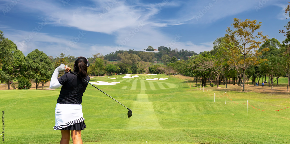 Professional woman golfer teeing golf in golf tournament competition at golf course for winner.  