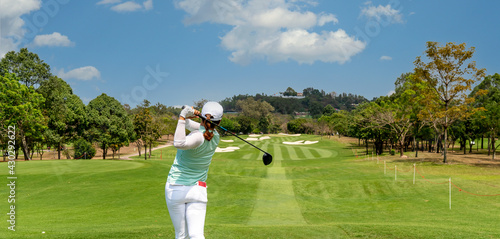 Professional woman golfer teeing golf in golf tournament competition at golf course for winner. 