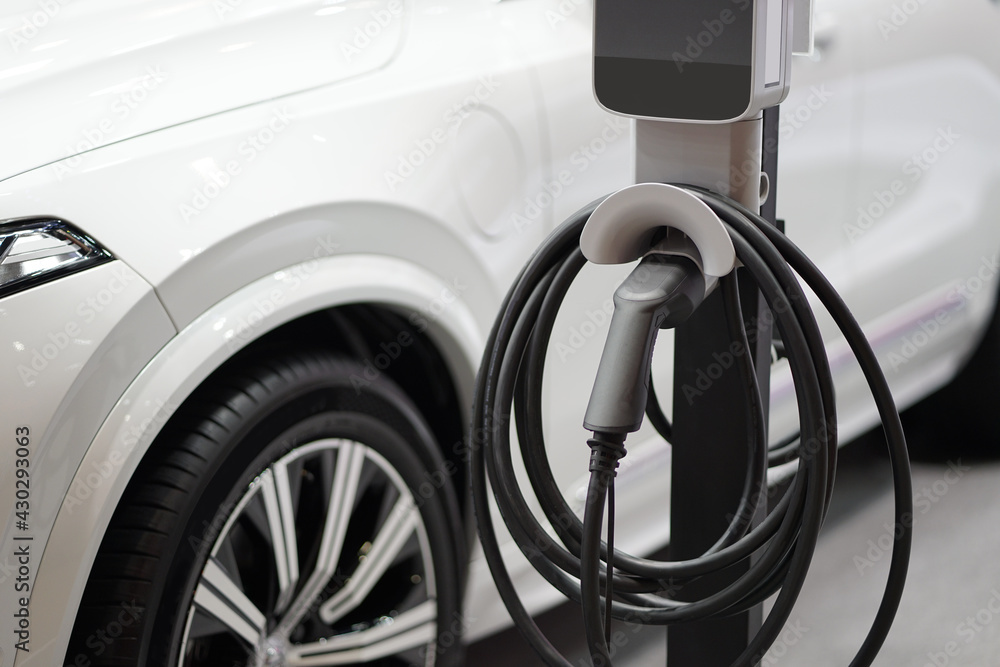 Electric car charging on parking lot with electric car charging station. Electric car charging on parking lot with electric car charging station.