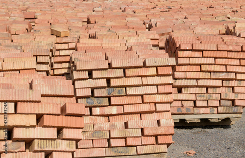 Red bricks on pallets. Backdrop concept for construction site  brick sale  warehouse.