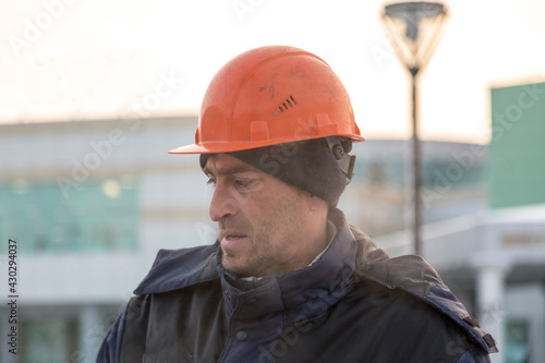 Portrait of a worker in a blue jacket with a hood at a construction site © ads861