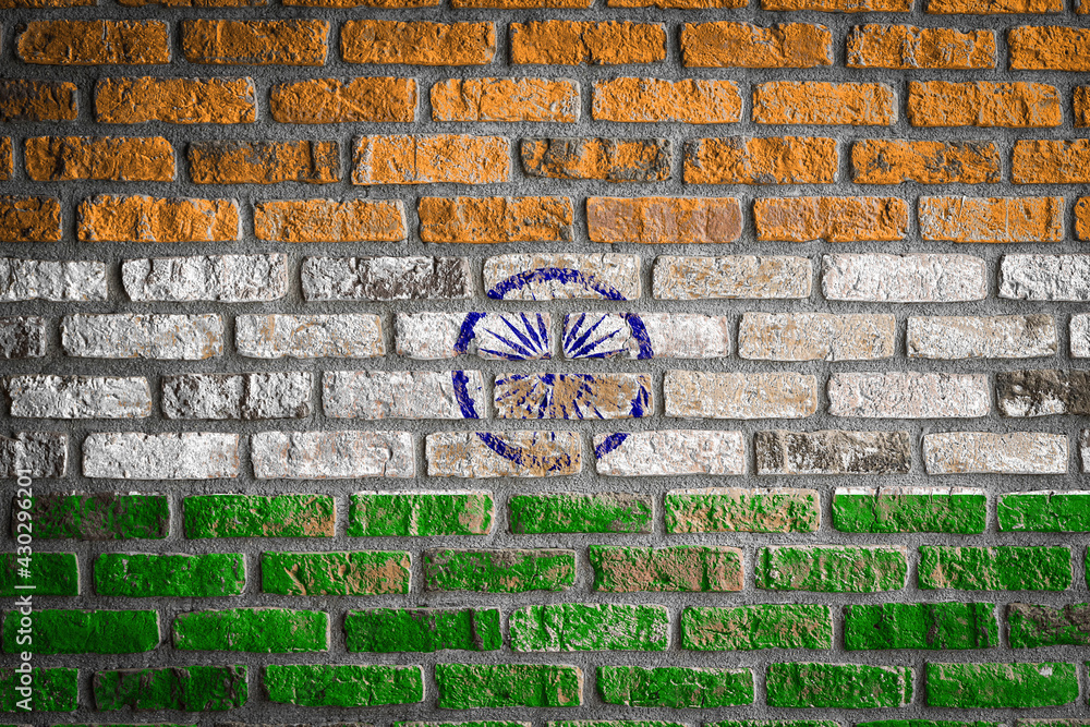 National flag of India depicting in paint colors on an old brick wall. Flag  banner on brick wall background.