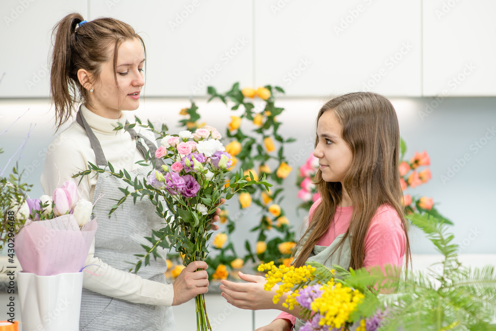 Florist teaches to young girl arranging flower at floral shop Florist teaches to young girl arranging flower at floral shop