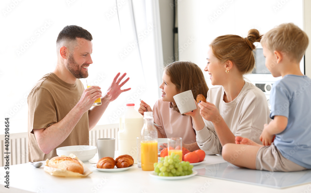 Young happy family having healthy breakfast in morning at home