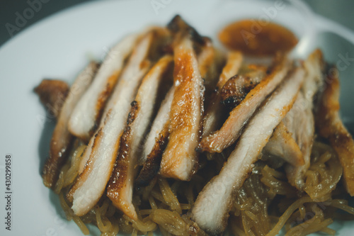 Grilled pork neck place on stir noodles, a popular appetizer in Thailand