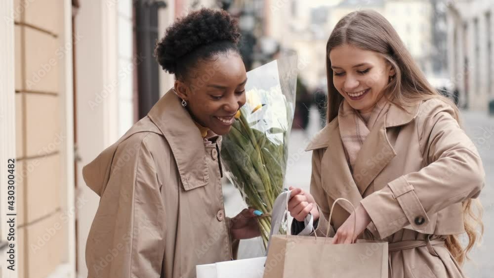 Two young women with shopping bags checking what they bought Two young women with shopping bags checking what they bought