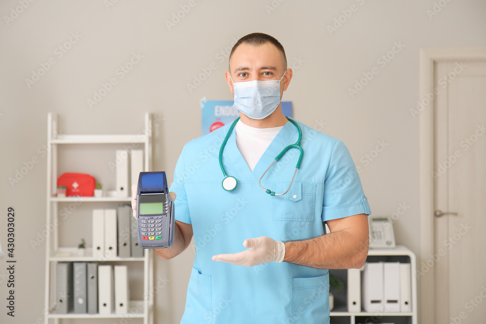 Doctor with payment terminal in clinic Doctor with payment terminal in clinic