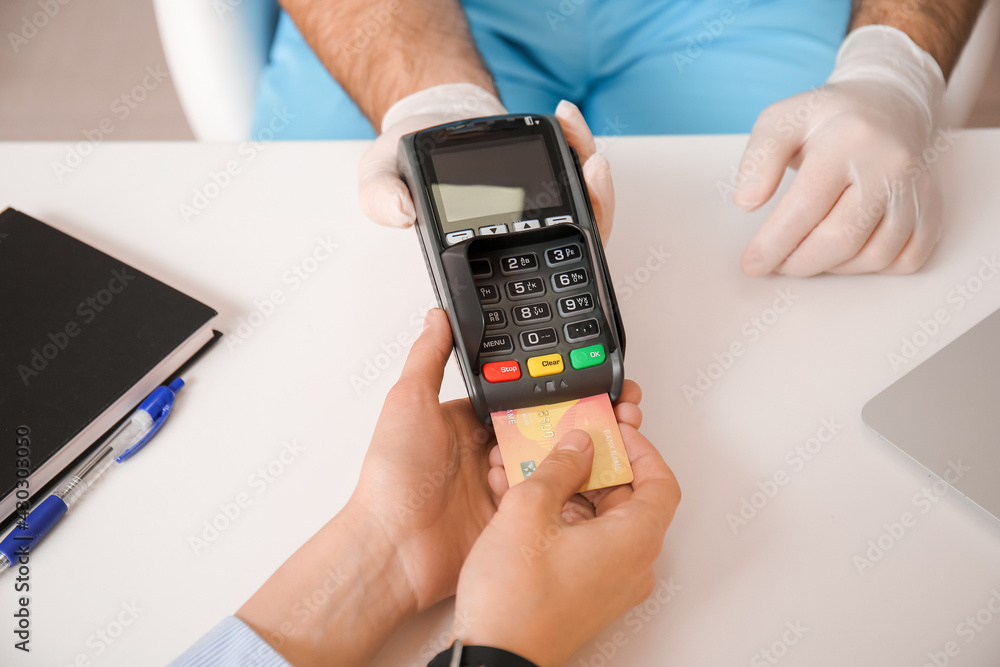 Patient paying for consultation in clinic via terminal Patient paying for consultation in clinic via terminal