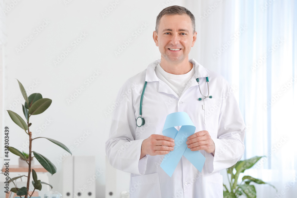 Oncologist with blue ribbon in clinic. Prostate cancer awareness concept Oncologist with blue ribbon in clinic. Prostate cancer awareness concept