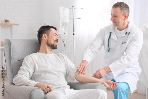 Doctor and man undergoing course of chemotherapy in clinic. Prostate cancer awareness concept photo