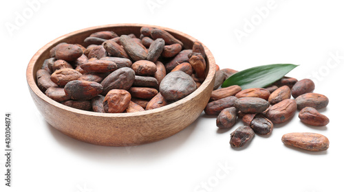 Bowl with cocoa beans on white background