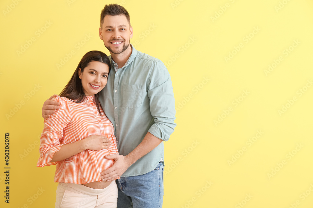Beautiful pregnant couple on color background Beautiful pregnant couple on color background