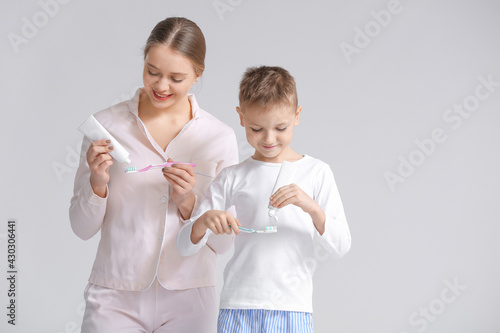 Mother and little son brush...