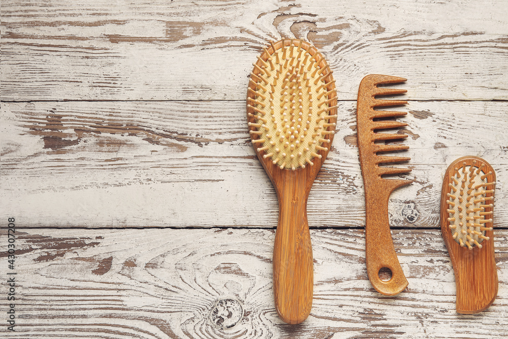Hair comb and brushes on white wooden background - obrazy, fototapety, plakaty 