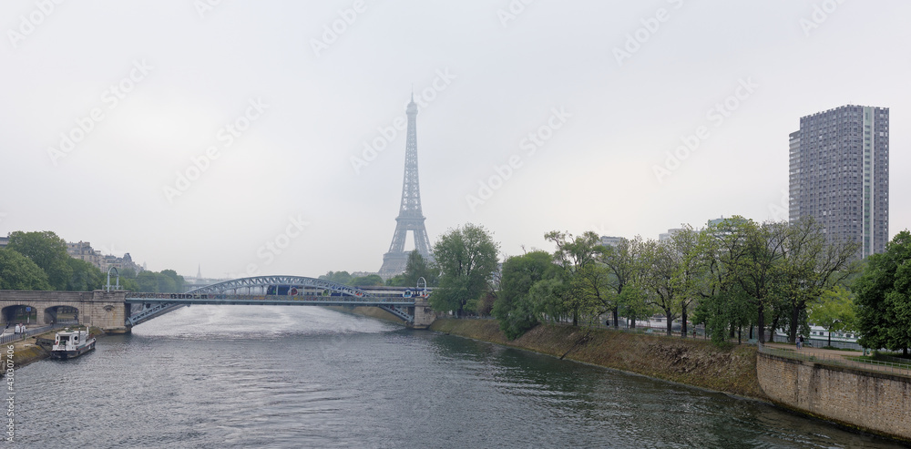 View of the Grenelle Bridge. On the embankment are moving cars and pedestrians, along the river-ship View of the Grenelle Bridge. On the embankment are moving cars and pedestrians, along the river-ship