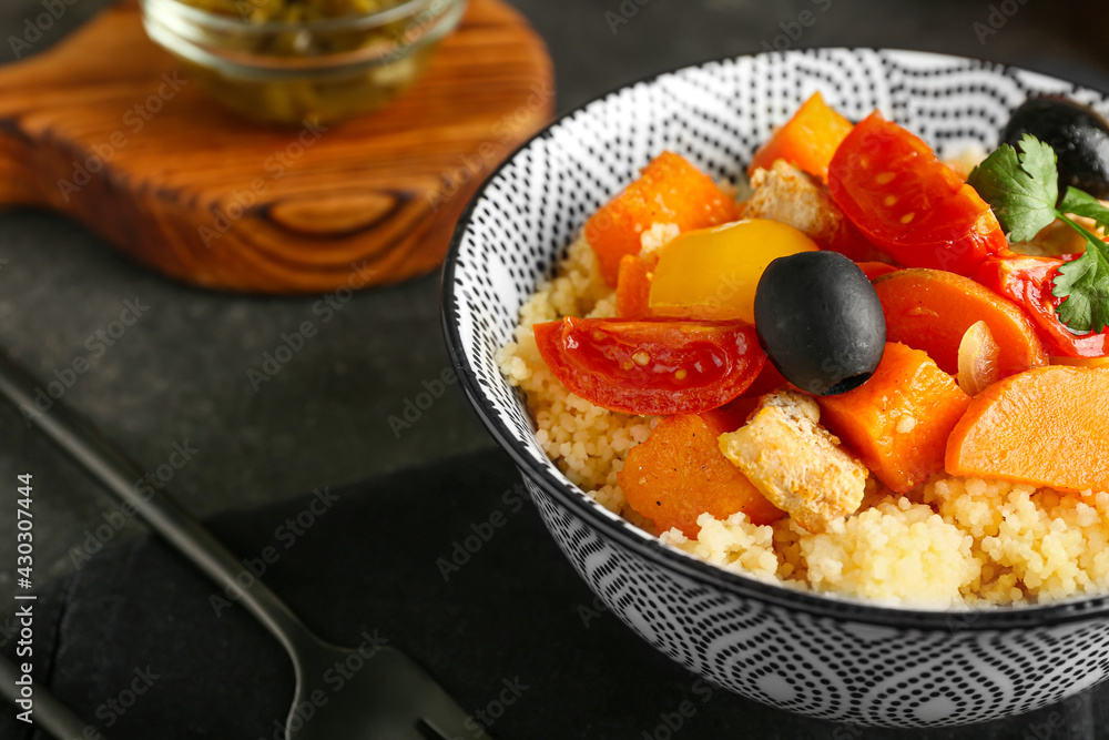 Bowl with couscous and vegetables on dark background Bowl with couscous and vegetables on dark background